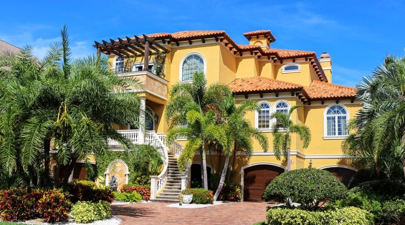 Grande maison jaune avec jardin et palmiers
