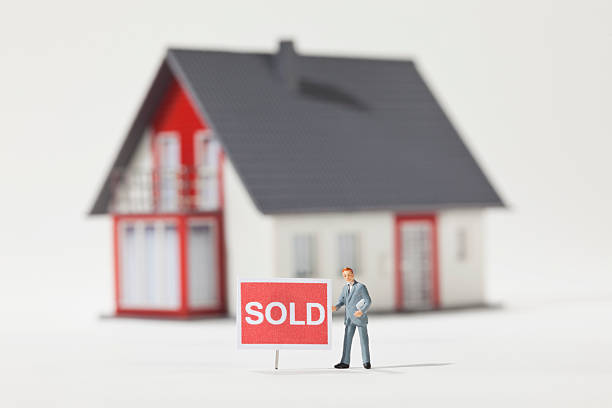 Maquette d'une maison avec un panneau "sold", soit "vendue"